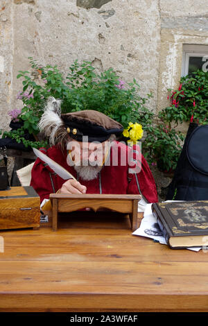 Ein Mann mit Vintage Lagerträger Dip Gänsefedern Handlungen eine Renaissance Schreiber während der mittelalterlichen Tage zu Thabor Herrenhaus in Mira Vas (Dorf), Vojnik. Slowenien. Stockfoto