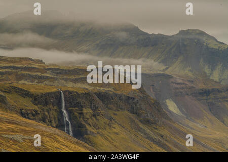 Isländische Landschaft der Halbinsel Snaefellsnes im Westen Islands mit Hügeln und einem Wasserfall. Stockfoto