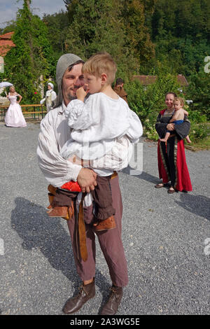 Mittelalterliche tage Re-enactment. Ein junges Paar' freeman Landwirte, halten ihre Kinder in den Armen. Tabor Mansion, Mira Vas (Dorf), Vojnok, Slowenien Stockfoto