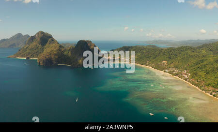 Antenne Drohne von tropischen Strand auf dem Hintergrund der Berge. Marine mit Blick auf das Meer, den Sand, Palmen. Corong corong Beach, El Nido, Palawan, Philippinen. Sommer und Reisen Urlaub Begriff Stockfoto