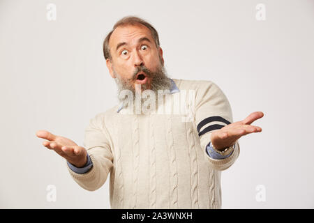 Portrait von älteren Mann mit Bart an Kamera und überrascht mit etwas auf weißem Hintergrund Stockfoto