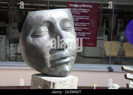 Swan Center, Leatherhead, Surrey, UK - Gesichtsstatue mit geschlossenen Augen im Swan Center außerhalb von Sainsburys in Leatherhead Stadt, 2019 Stockfoto