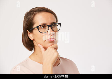 Junge Frau in Brillen weg schauen mit nachdenklichen Ausdruck auf weißem Hintergrund Stockfoto