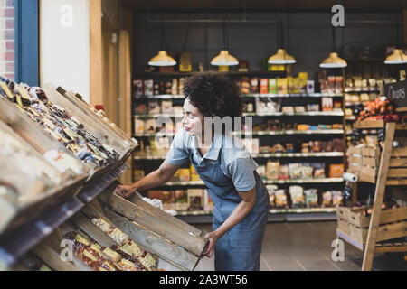 Inhaber kleiner Unternehmen von einem Lebensmittelmarkt Strumpf Regale Stockfoto