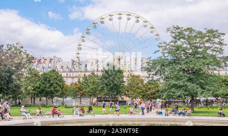 Die Leute, die einen Bruch in die Tuilerien mit Riesenrad im Hintergrund Stockfoto