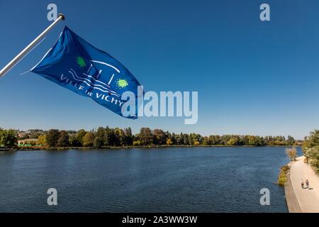 Die VICHY RATHAUS Flagge hängt über der Brücke über den Fluss Allier und seine Ufer, Vichy, ALLIER, Auvergne, RHÔNE-ALPES, Frankreich Stockfoto