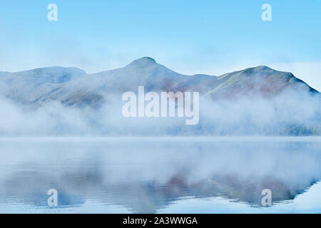 Dawn Cloud beginnt, scheint die Sonne durch den Nebel auf Cat Glocken zu zerstreuen am See Derwentwater, Lake District, Cumbria, England fiel. Stockfoto