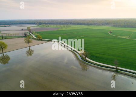 Überschwemmte Felder für den Reisanbau in der Poebene, in Italien. Panoramablick auf das Luftbild. Typische Landschaft Landschaft Norditaliens mit unbefestigten Straßen, f Stockfoto