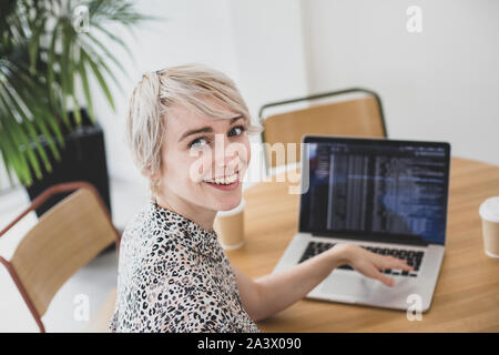 Portrait einer weiblichen Coder, der an einem Notebook arbeitet Stockfoto