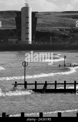 Hafen Aberdeen Control Tower, über dem Strand mit hölzernen Buhnen und Nordsee Wellen. Schottland, Großbritannien. Stockfoto