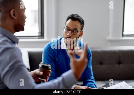 Portrait oder ein indischer Geschäftsmann sprechen in eine vielfältige Gruppe von jungen kreativen Entwickler Ideen diskutieren und zur Festlegung von Dokumenten bei einem Brainstorming. Stockfoto