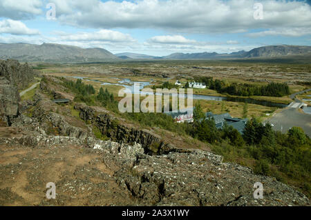 Panoramablick auf die malerische Aussicht auf einer kurvigen Fluss, Tal, Bauernhäuser und Berge in Island Stockfoto