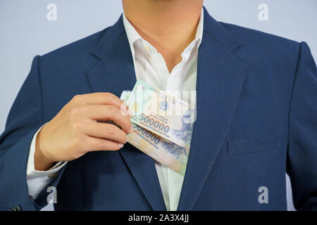 Geld in Vietnam halten an Hand der Mann trägt einen blauen Anzug (Sozialistische Republik Vietnam), Dong, VND, Bezahlung, Geld Vietnamesen auf weißem Bac Stockfoto