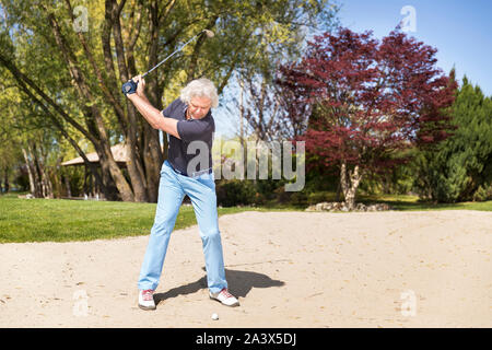Männliche ältere Golf Spieler im Bunker. Stockfoto