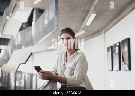 Portrait von weiblichen executive Holding ein Smartphone Stockfoto