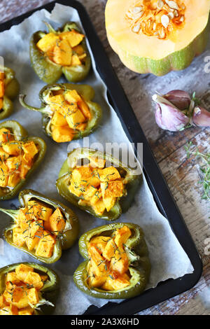 Paprika Paprika gefüllt mit Kürbis. Gebackene Paprika mit Kürbis. Veganes Mittagessen. Herbst essen. Selektive konzentrieren. Makro. Stockfoto