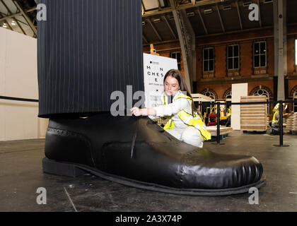 Ein paar riesige Beine als "heimliche" Messung über 10 Meter in der Höhe bekannt sind, errichtet an der Aviva Investors Manchester Art Fair an der Manchester Central über 11.-13. Oktober 2019. Die Beine sind die Arbeit der 23 Jahre alte Manchester School of Art graduate Millie Sansom. Die Installation ist aus Stoff, Polystyrol und Kunstleder und demonstriert das Ungleichgewicht der Machtverteilung zwischen Bürgern und politischen oder Corporate "Riesen". Stockfoto