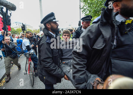 London, Großbritannien. 10. Oktober 2019. Ein Aktivist, nachdem man von einem hölzernen Struktur entfernt werden, wird von der Polizei auf dem Trafalgar Square in Tag 4 des Erdklimas Aussterben Rebellion ändern Protest in der Hauptstadt durchgeführt. Die Aktivisten fordern von der Regierung auf, unverzüglich Maßnahmen gegen die negativen Auswirkungen des Klimawandels zu ergreifen. Credit: Stephen Chung/Alamy leben Nachrichten Stockfoto