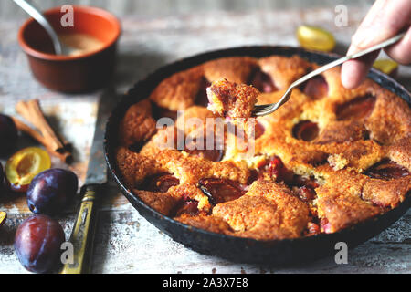 Selektive konzentrieren. Stück Pflaumenkuchen auf eine Gabel. Hausgemachte amerikanische Pflaumenkuchen. Makro. Stockfoto