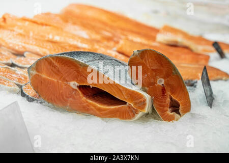 Stücke und Filet vom Lachs, Teile auf Eis im Supermarkt. Verkauf von Meeresfrüchten, Fisch. Offene Vitrinen, Counter von Seafood Market Stockfoto