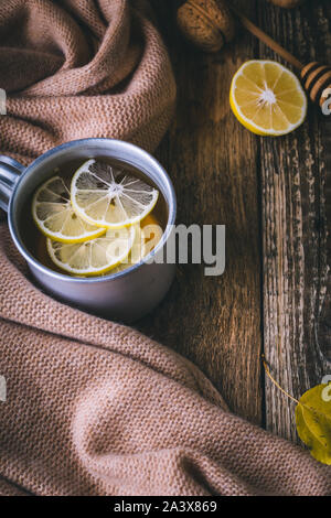 Heißen Tee und frische Zitrone auf Holz Tisch, Herbst Tea Time. Weihnachten und Thanksgiving Tag gemütlich warmen Getränke- und Wollschal, in der Nähe Stockfoto