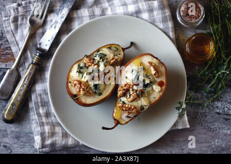 Selektive konzentrieren. Gebackene Birnen mit dor Blauschimmelkäse auf einer Platte. Gesundes Mittagessen. Keto Diät. Keto Snack. Stockfoto