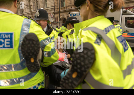 Trafalgar Square, London, Großbritannien. Oktober 2019. Polizisten der Metropolitan Police verhaften und transportieren einen Aktivisten der Extinction Rebellion während des Protestes der Oktoberaufstände am Trafalgar Square, London. Die Verhaftung erfolgte im Rahmen einer koordinierten Reaktion der Polizei auf das Klimaschutzlager. Penelope Barritt/Alamy Live News Stockfoto