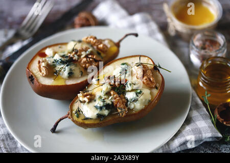 Selektive konzentrieren. Gebackene Birnen mit dor Blauschimmelkäse auf einer Platte. Gesundes Mittagessen. Keto Diät. Keto Snack. Stockfoto