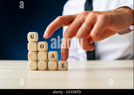 Geschäftsmann mit seinem Finger nach oben klettern die Schritte Rechtschreibung das Wort Ziel in einem konzeptionellen Bild des Unternehmens Vision und Ehrgeiz. Stockfoto