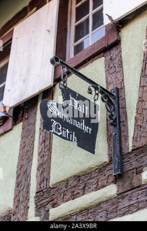 D'alt Schuamacher Butik, einem alten Schuhmacher oder cobblers Schild auf einem alten Hälfte timered Gebäude in Eguisheim Elsass Frankreich Stockfoto