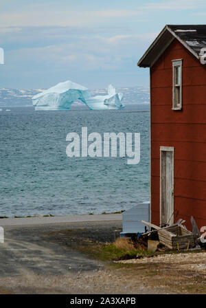 Eisberg auf der Grünen Insel Bucht mit Red Barn im Vordergrund, Neufundland Stockfoto