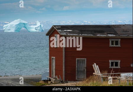 Eisberg auf der Grünen Insel Bucht mit Red Barn im Vordergrund, Neufundland Stockfoto