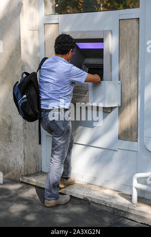 Mann mit ATM, automatisierte Bank- maschine, Automated Teller Machine, Automatic Teller Machine, Bancomat, Bankomat, Geldautomaten, Geldautomat. Stockfoto