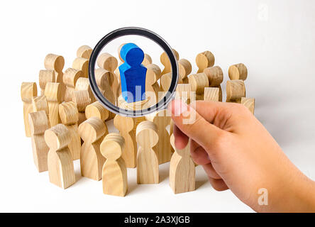 Eine Lupe schaut auf die blau Abbildung eines Mannes, der in der Mitte einer Masse von Menschen. Führung und Team Management, ein Beispiel für die Nachahmung. Loy Stockfoto