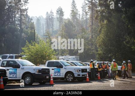 Oktober 10, 2019, Big Oak Flat/Groveland, Kalifornien, USA: Mountain G. Enterprises, Inc. (MGE) Mitarbeiter sammeln für eine Sitzung Donnerstag Morgen im Yosemite gateway Gemeinschaft der großen Eiche Flach/Groveland,] unter diesigen Himmel. Die Briceburg Feuer brennt in der Nähe, und der Rauch hat in der Gemeinschaft. MGE ist ein Notfall vegetation Management Unternehmen von PG&E während der aktuellen Herunterfahren abgeschlossen. Zum Schutz der öffentlichen Sicherheit, PG&E hat den Strom für rund 34.400 Kunden in Tuolumne County wegen böigen Winde und trockene Bedingungen mit erhöhtem Brandrisiko kombiniert. Sobald die weat Stockfoto