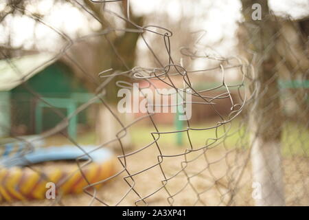 Alte verbogen Maschendrahtzaun. Selektive konzentrieren. Herbstliche Stimmung. Stockfoto