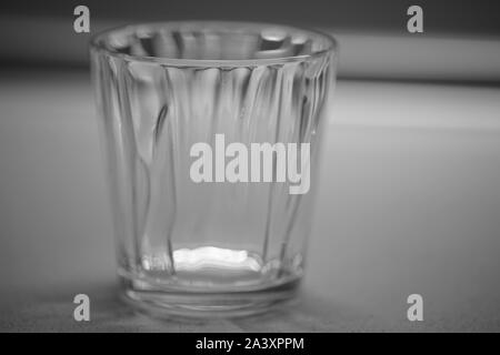 Leeres Glas Wasser auf einen Tisch, close-up, Schwarz und Weiß Foto Stockfoto