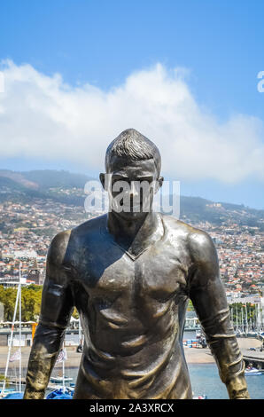 Funchal, Madeira, Portugal - 14.September 2019: Statue des berühmten Fußballer Cristiano Ronaldo in Portugiesisch Funchal. Stadt Funchal und den Hafen im Hintergrund. Teil von CR7 Museum. Fußball, Fußball-Spieler. Stockfoto