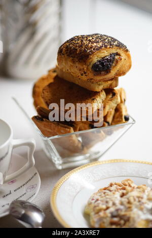 Tea Time. Zwieback und Croissants mit Mohn in einem Glas Vase. Stockfoto