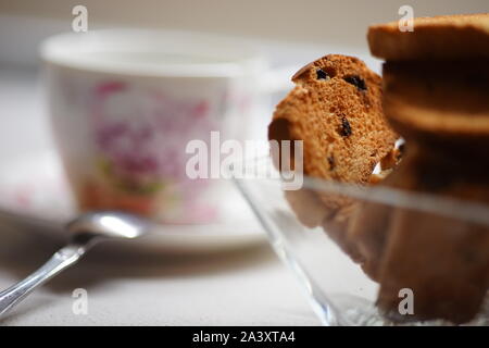 Tea Time. Cracker in einem Glas Vase, Schale mit Tee auf den verschwommenen Hintergrund. Stockfoto