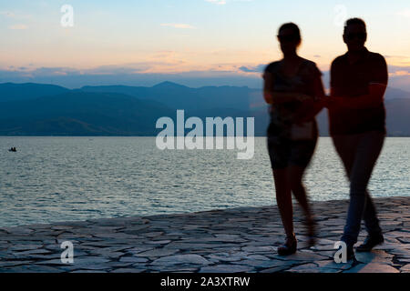 Silhouetten von Paar verschwommen in Bewegung, als sie Rock weg mit Sonne hinter gehen. Stockfoto