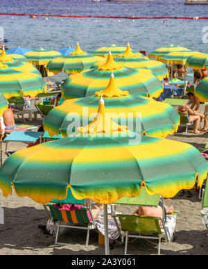 AMALFI, ITALIEN - AUGUST 2019: Bunte gelb und grün Sonnenschirme am Strand von Amalfi Stockfoto