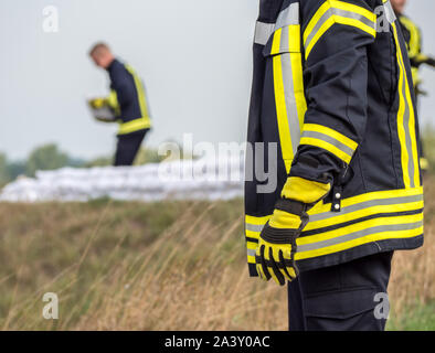 Sandsäcke Hochwasserschutz Feuerwehrmann Stockfoto