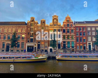 Amsterdam, Niederlande - Oktober 2,2019: Amsterdam Canal Singel mit typisch holländische Häuser und Hausboote, Boote am Abend mit schönen Wasser re Stockfoto