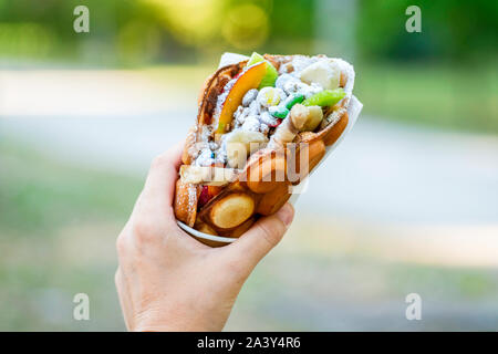 Hong Kong Stil ei Waffeln in weiblicher Hand. Weibliche hand mit süßen bubble Waffel. Stockfoto