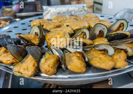 Chon Buri, Thailand - März 16, 2019: Nahaufnahme von Haufen gebratene Muscheln in gelben Teig auf der Straße Markt in der Sukhumvit Road. Stockfoto