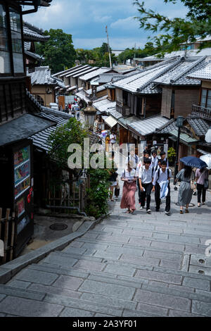 Gruppe von jungen Studenten eine Treppe in einer traditionellen Straße von alten Häusern des Gion-Distrikts umgeben klettern. Kyoto, Japan. Stockfoto