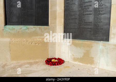 Ein roter Mohn Kranz vor dem Namen der Kriegstoten an einem Kriegerdenkmal festgelegt Stockfoto