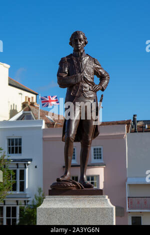 Eine Statue von Horatio Nelson mit einem Union Jack Flagge im Hintergrund, Portsmouth Großbritannien Stockfoto