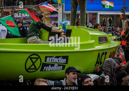 New York City, USA. 10 Okt, 2019. Klima Aktivisten angeschlossen mit der globalen Umwelt Gruppe? Aussterben Rebellion' inszeniert eine gewaltfreie Akt zivilen Ungehorsams' in der Mitte des Times Square, Sperrung des Verkehrs für etwa eine Stunde. Die Demonstranten ein Lime Green Boot an der Kreuzung von Broadway und 44th Street geparkt, das Schiff umgeben und fuhr fort, sich Kette zu Sekundenkleber. Entsprechend der NYPD, 62 Demonstranten wurden festgenommen. (Foto von Michael Nigro/Pacific Press) Quelle: Pacific Press Agency/Alamy leben Nachrichten Stockfoto